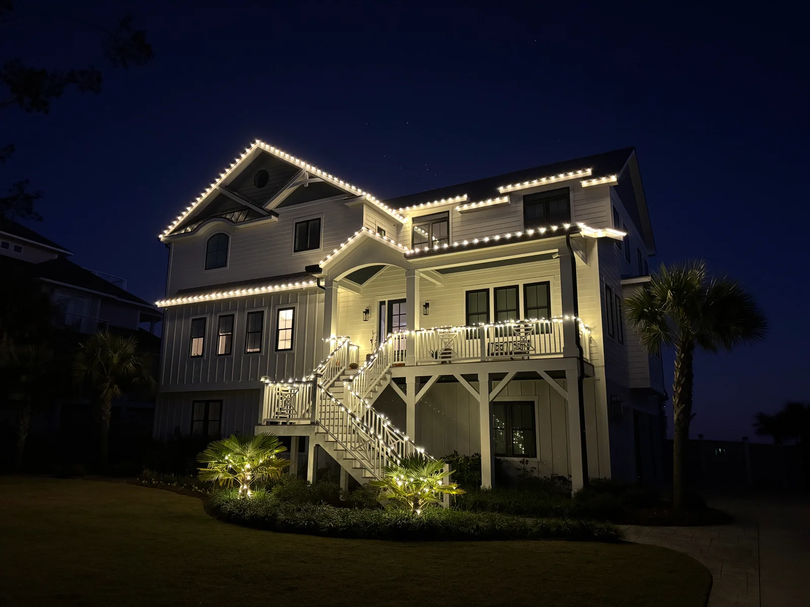 Two-story white house with elevated deck and railings, cleaned exterior siding and trim