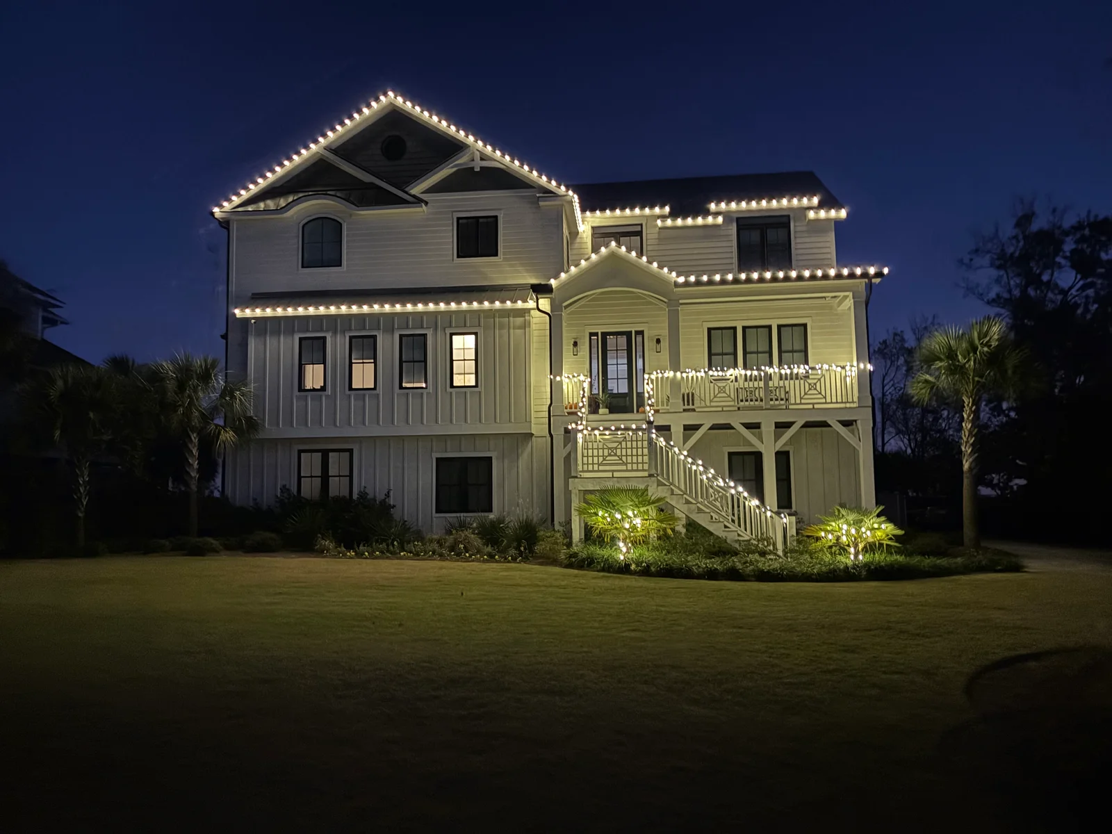 Two-story white house with deck and railings, cleaned exterior siding and surfaces
